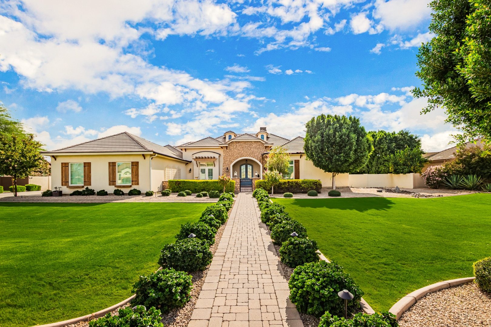 Daytime exterior real estate photo of a luxury Arizona estate home with manicured lawn